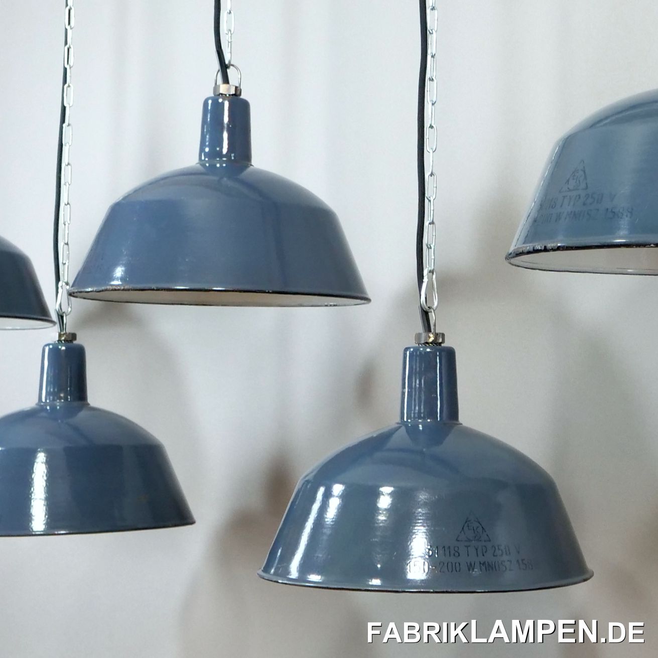  Alte Emaille Industrielampen in graublau mit Herstellermarke.

Die alten Industrielampen haben geringe Spuren der vergangenen Jahrzehnte (Abplatzer, Roststellen, Kratzer, Verfärbungen und Co.).

Die Fabriklampen sind restauriert: gereinigt, konserviert und neu elektrifiziert, mit neuen E27 Keramikfassungen.

Material: graublau (innen weiss) emailliertes Stahlblech. Wir haben diese Leuchten auch in anderen Farbtönen, von hellblau bis dunkelblau. Von dieser Lampenfamilie haben wir auch einige ziemlich seltene hellgraue Exemplare sowie die schwarze/anthrazite Ausführung auf Lager (auf Anfrage). Diese alten Industrieleuchten existieren auch mit weißer Beschriftung, diese Ausführung haben wir ebenfalls auf Lager.

Sie bekommen die Lampen mit 2 Meter Textilkabel in Farbe Ihrer Wahl und massiver Aufhängeöse für die sichere Aufhängung. Gegen Aufpreis können die Lampen auch mit Ketten- oder Stahlrohr-Aufhängung geliefert werden. Baldachine können wir auch anbieten.

Die Abmessungen: Höhe der Lampen ca. 26 cm (ohne Öse), Durchmesser ca. 36 cm. 