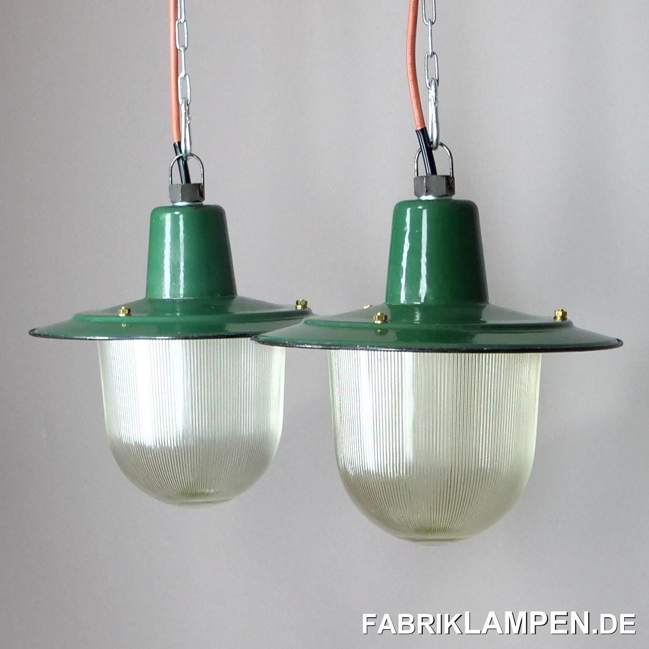  Alte Emaille Fabriklampen aus den 1950er Jahren, ein Paar. Sehr seltene Variante mit Firmenlogo auf dem Emailschirm und Schutzglas. Das schwere Thermoglas ist gerippelt.

Diese schönen Fabriklampen haben einige Spuren der vergangenen Jahrzehnte, wie Abplatzer, Roststellen, Kratzer, Verfärbungen und Co. Damit ist jede einzelne Lampe ein Unikat.

Die Industrielampen sind restauriert: gereinigt, konserviert und neu elektrifiziert, mit neuen E27 Keramikfassungen.

Material: grün (innen weiß) emailliertes Stahlblech, mit Schutzglas.

Die Lampen können auch ohne Glas, als offene Leuchten verwendet werden.

Die Abmessungen: Höhe der Lampen ca. 28 cm (ohne Aufhängeöse), Durchmesser ca. 31,5 cm. Höhe des Schirms lediglich 12 cm.

Die alten Fabriklampen werden mit 2 Meter Kabel geliefert. Gegen Aufpreis können die Lampen auch mit Ketten- oder Stahlrohr-Aufhängung geliefert werden. Baldachine können wir auch anbieten.
 